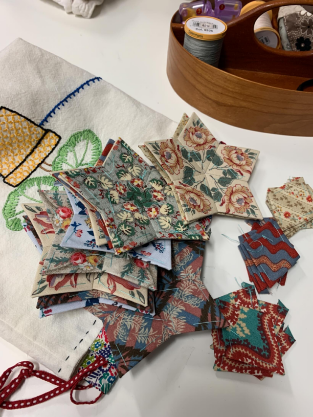 I cannot tell you how many times I got up and down off the floor today laying out quilts for book photography 😟. So a little lunch time stitching was a nice relief. Day three tomorrow in the studio and I cannot tell you how excited I am about @searchpress_na @searchpress vision for my book coming out late 2026 📕. #patchwork #epp #fussycutting #quiltmaking #handstitching #handstitched #searchpress #carolynforster #carolynforsterquilts